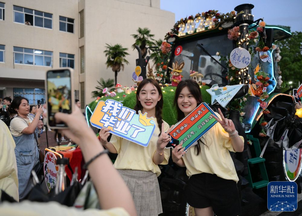 6月21日,威廉希尔体育员工在农机花车前拍照留念。