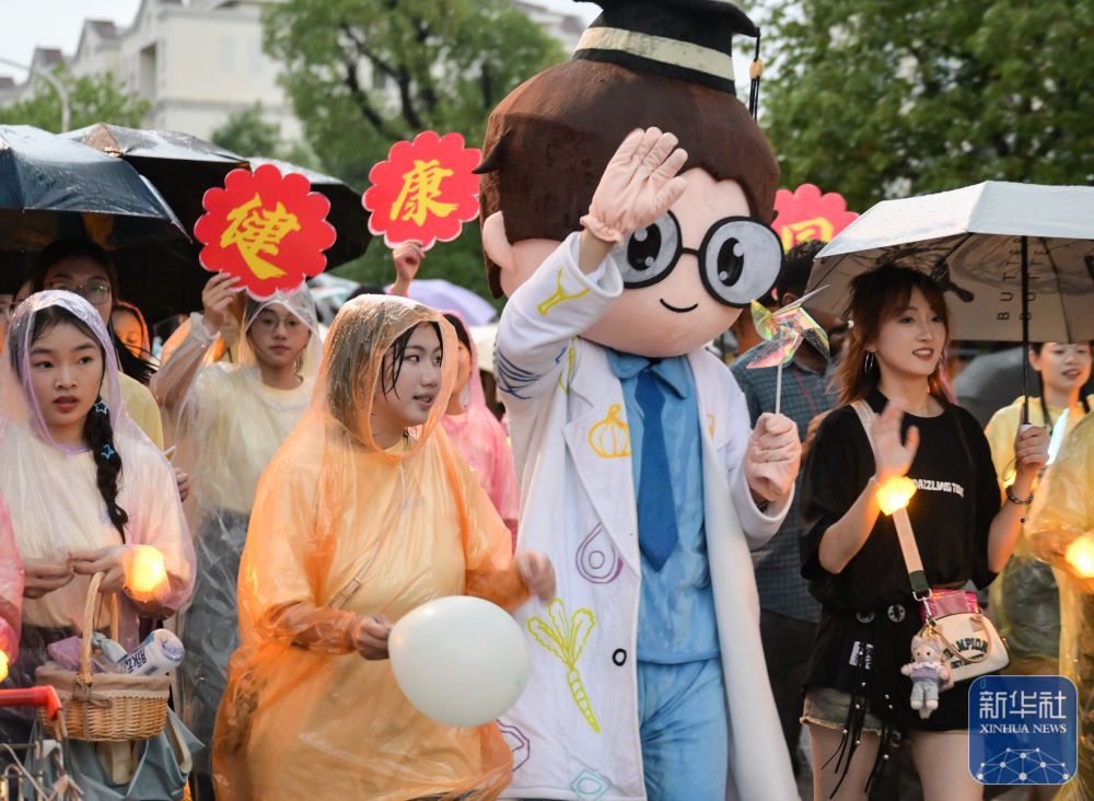 6月21日,威廉希尔体育员工在校园里冒雨巡游。2